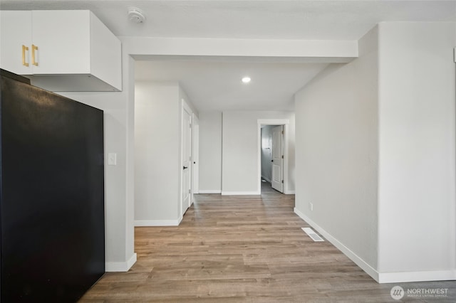 corridor featuring light wood finished floors, recessed lighting, visible vents, and baseboards