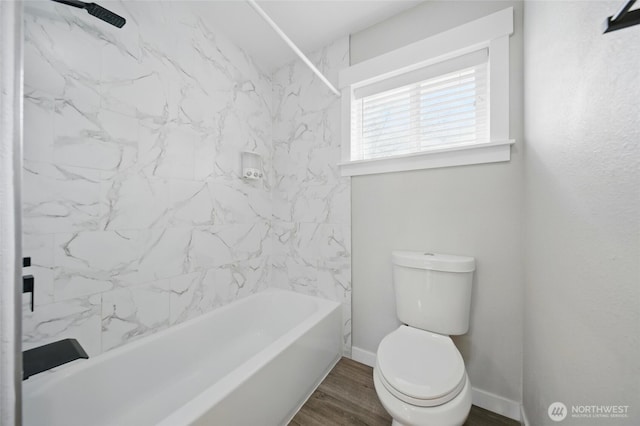 full bathroom with baseboards, wood finished floors, toilet, and washtub / shower combination