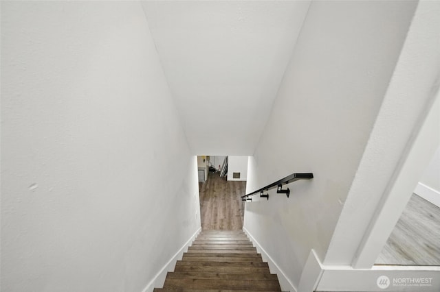 stairway with wood finished floors and baseboards