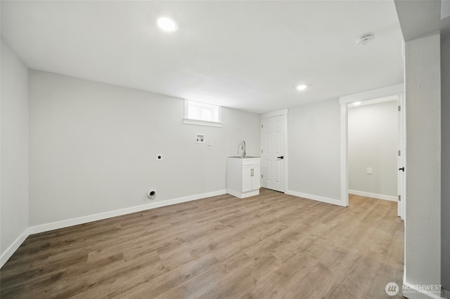 basement featuring baseboards, recessed lighting, light wood finished floors, and a sink