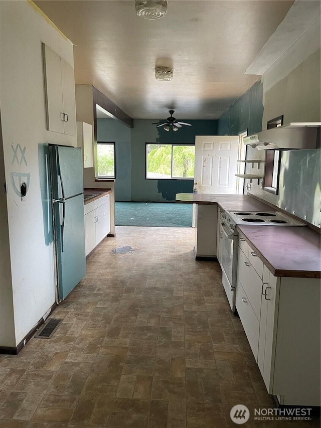 kitchen with freestanding refrigerator, dark countertops, white electric range, white cabinetry, and a ceiling fan