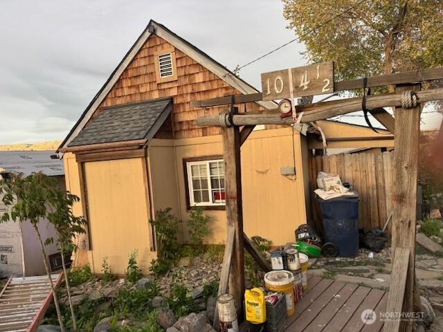view of side of property with roof with shingles