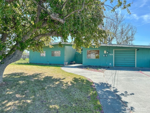 view of front of house with a front yard, aphalt driveway, and a garage