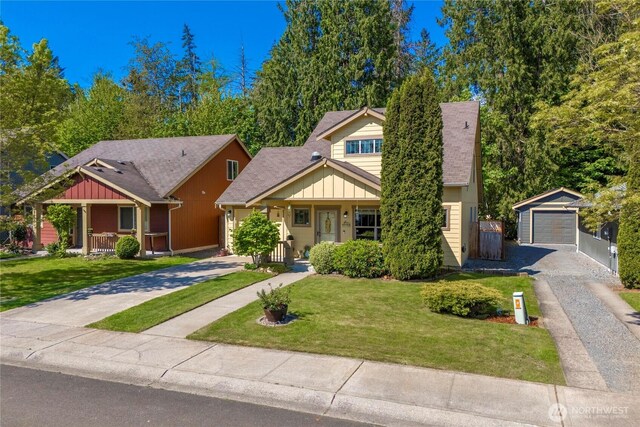 bungalow with an outdoor structure, board and batten siding, covered porch, and driveway
