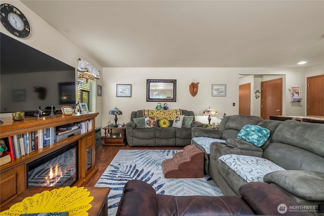 living room with recessed lighting, a glass covered fireplace, and wood finished floors