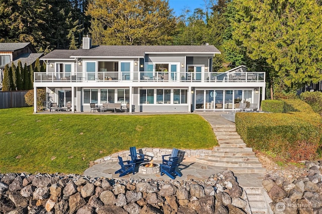 13967 SW 248th St, Vashon, WA 98070 - rear view of house featuring a fire pit, a balcony, a chimney, a patio area, and a lawn