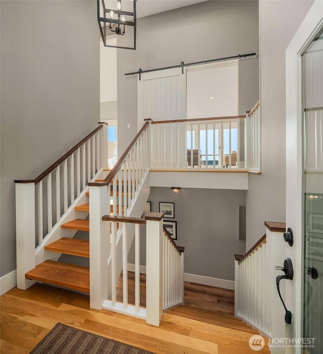 13967 SW 248th St, Vashon, WA 98070 - stairway featuring baseboards, a barn door, a high ceiling, and wood finished floors