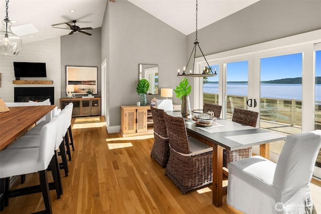 13967 SW 248th St, Vashon, WA 98070 - dining area with wood finished floors, a fireplace, baseboards, high vaulted ceiling, and ceiling fan with notable chandelier