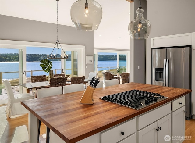 13967 SW 248th St, Vashon, WA 98070 - kitchen featuring wooden counters, appliances with stainless steel finishes, light wood-type flooring, white cabinets, and a notable chandelier