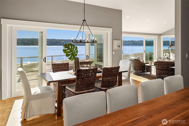 13967 SW 248th St, Vashon, WA 98070 - dining area featuring a water view, a chandelier, vaulted ceiling, and light wood-type flooring