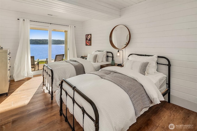 13967 SW 248th St, Vashon, WA 98070 - bedroom featuring visible vents, wood walls, wood finished floors, access to outside, and a water view