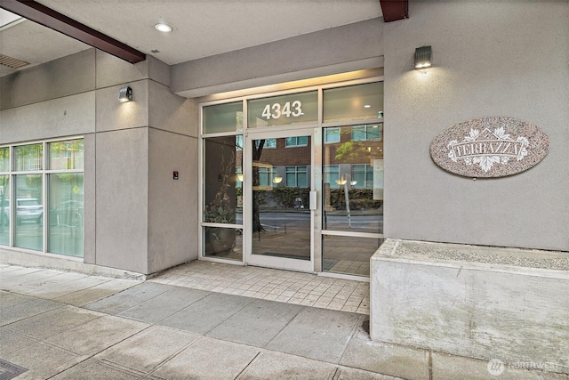 view of exterior entry with stucco siding