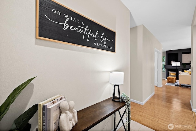 corridor with baseboards and wood finished floors