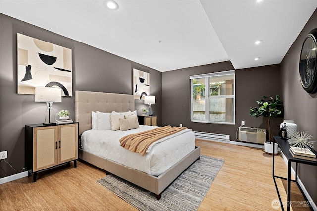 bedroom with recessed lighting, baseboards, wood finished floors, a baseboard heating unit, and a wall mounted AC