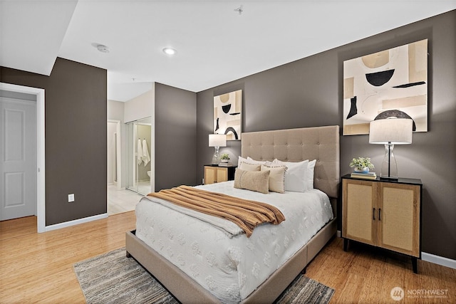 bedroom featuring connected bathroom, recessed lighting, baseboards, and light wood-style floors