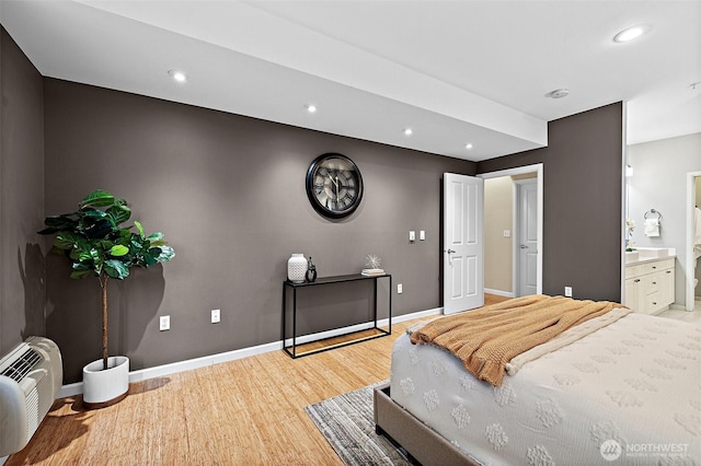 bedroom with baseboards, ensuite bath, recessed lighting, and light wood-style flooring