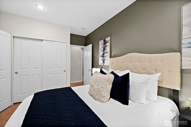 bedroom with recessed lighting, wood finished floors, and a closet