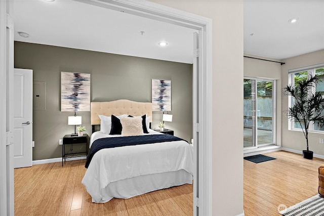 bedroom with baseboards, recessed lighting, wood finished floors, and access to exterior