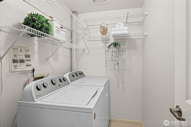 laundry area with laundry area, baseboards, and washing machine and clothes dryer