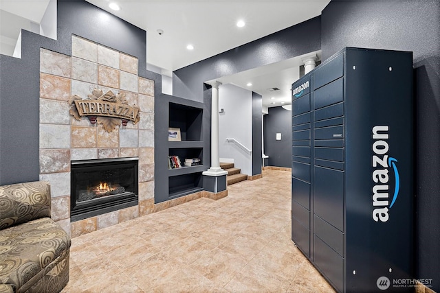 tiled living room with recessed lighting, stairs, a fireplace, and built in shelves