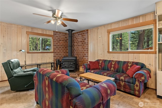 225C Lost River Rd, Mazama, WA 98833 - living room featuring a ceiling fan, wood walls, and a wood stove
