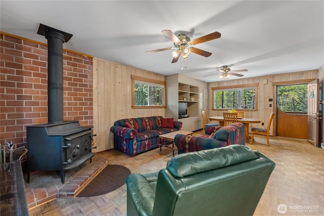 225C Lost River Rd, Mazama, WA 98833 - living room with a wood stove, a ceiling fan, and wood walls