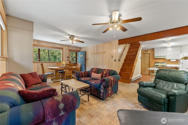 225C Lost River Rd, Mazama, WA 98833 - living room featuring stairway, baseboard heating, a ceiling fan, and wood walls