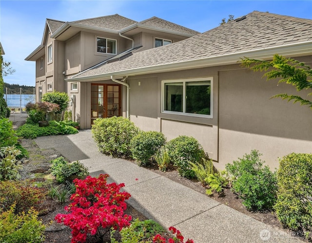 4582 Point White Dr NE, Bainbridge Island, WA 98110 - view of front facade with stucco siding, roof with shingles, and french doors