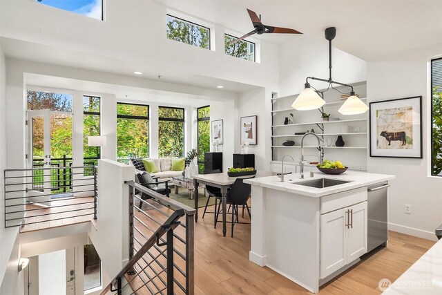 kitchen featuring light countertops, open shelves, a wealth of natural light, and a sink