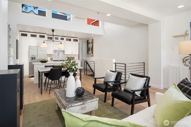 living room featuring light wood finished floors and a high ceiling