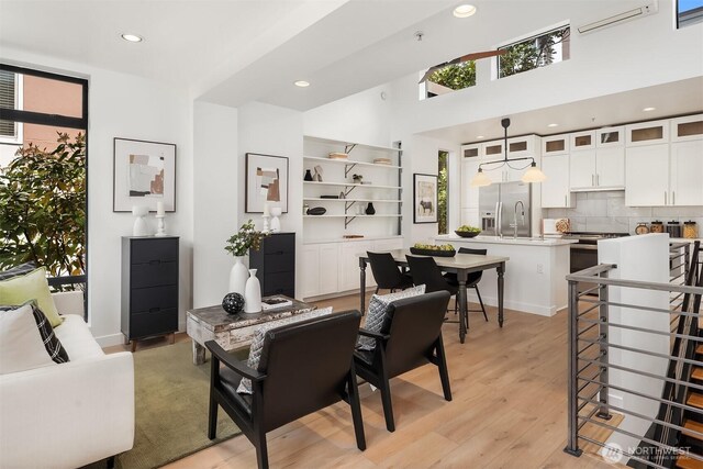living area featuring recessed lighting, a wall mounted AC, and light wood-style flooring