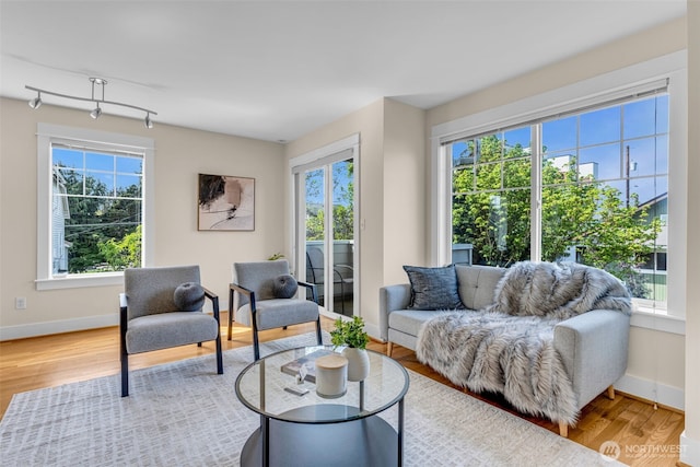 living area with baseboards and wood finished floors