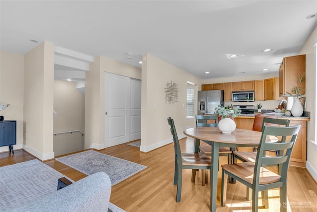 dining space featuring recessed lighting, baseboards, and light wood finished floors