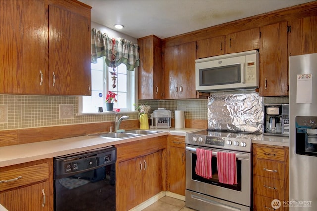 kitchen featuring light countertops, a sink, tasteful backsplash, and stainless steel appliances