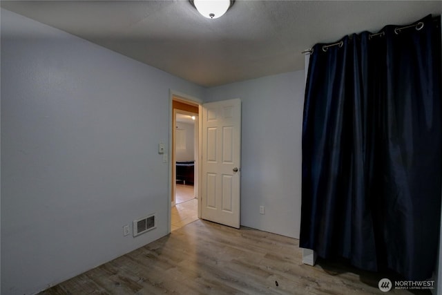 unfurnished room featuring visible vents and light wood-style floors