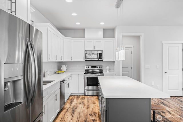 1824 E Fairbanks St, Tacoma, WA 98404 - kitchen with stainless steel appliances, recessed lighting, light countertops, light wood finished floors, and white cabinetry