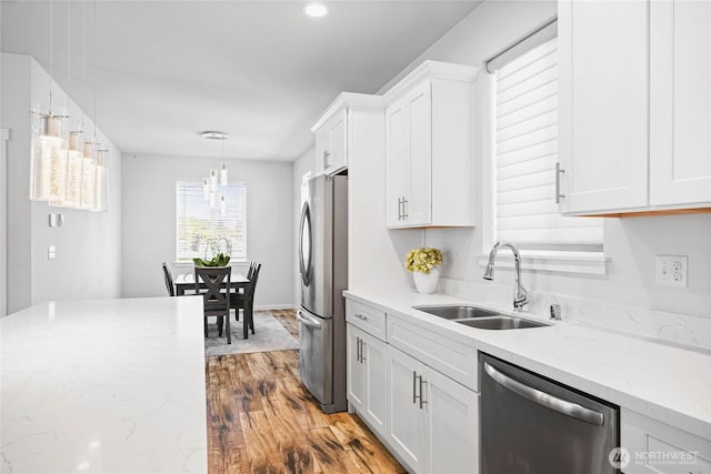 1824 E Fairbanks St, Tacoma, WA 98404 - kitchen with appliances with stainless steel finishes, a sink, white cabinets, wood finished floors, and light stone countertops