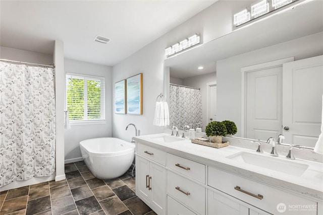 1824 E Fairbanks St, Tacoma, WA 98404 - bathroom featuring double vanity, baseboards, a freestanding bath, and stone finish flooring