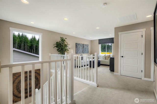 corridor with recessed lighting, carpet flooring, an upstairs landing, visible vents, and baseboards