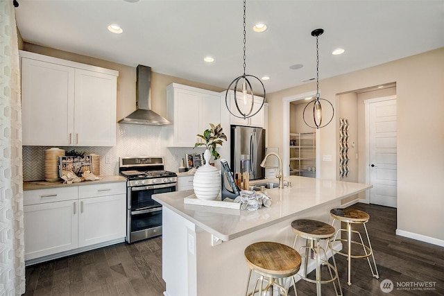kitchen featuring wall chimney range hood, white cabinetry, stainless steel appliances, dark wood-type flooring, and backsplash