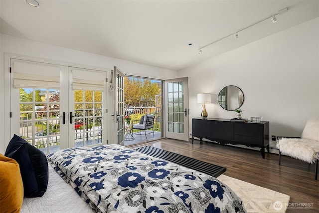 bedroom featuring access to outside, multiple windows, french doors, and wood finished floors