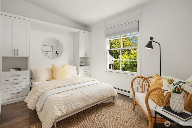 bedroom with lofted ceiling, wood finished floors, and baseboard heating