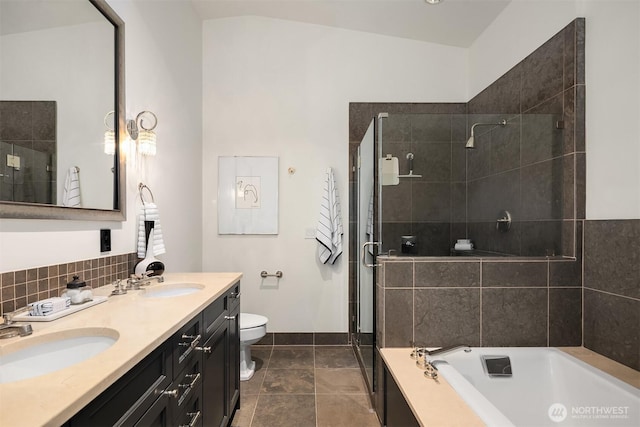 bathroom featuring a garden tub, a sink, toilet, and a shower stall