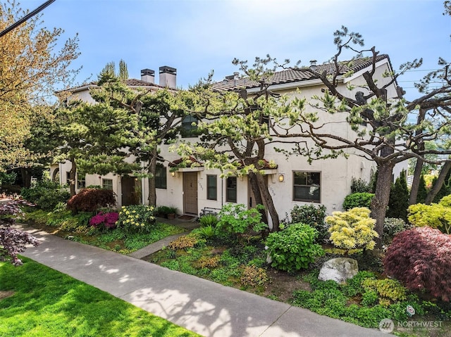 view of front of property with a chimney and stucco siding