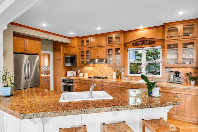 7854 Stroud Ave N, Seattle, WA 98103 - kitchen featuring a sink, a kitchen breakfast bar, under cabinet range hood, backsplash, and appliances with stainless steel finishes