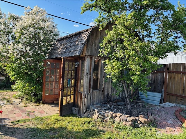 view of outbuilding with fence and an outbuilding