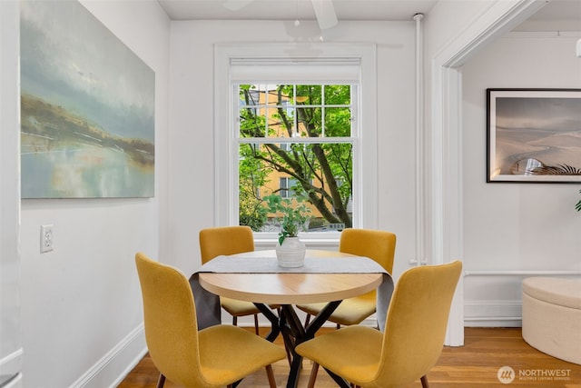 dining area with baseboards, a ceiling fan, and wood finished floors