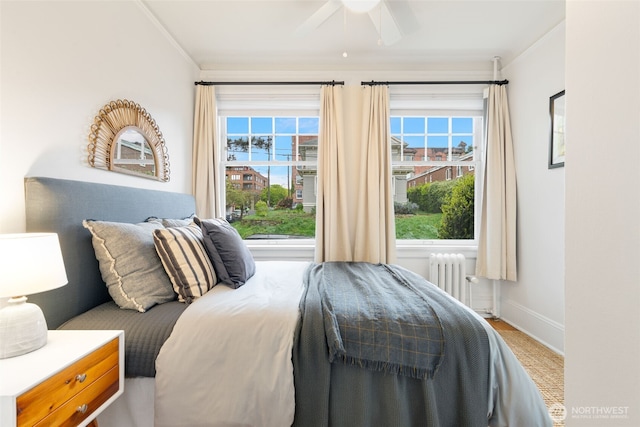 bedroom featuring baseboards, a ceiling fan, crown molding, and radiator heating unit