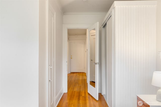 hall with light wood-style floors and crown molding