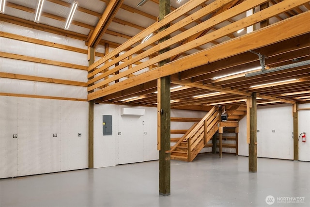 garage with a wall unit AC and electric panel